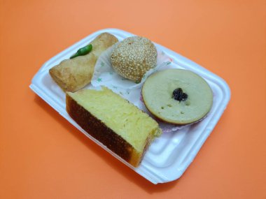 Snacks from the market consisting of mud cakes, apem cakes, spring rolls, steamed slices of bread, round bread filled with chocolate
