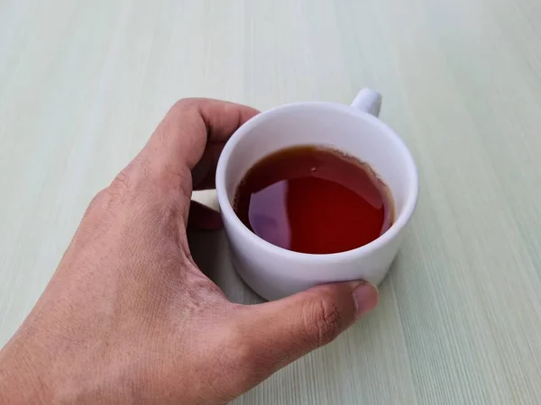 Teenage Boy Hand Holding White Mug Filled Tea White Background — Zdjęcie stockowe