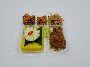 Yellow rice with fried chicken, fried noodles, fried chili and others