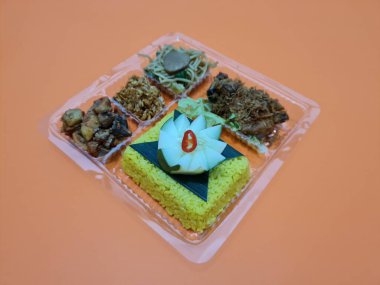 Yellow rice with fried chicken, fried noodles, fried chili and others