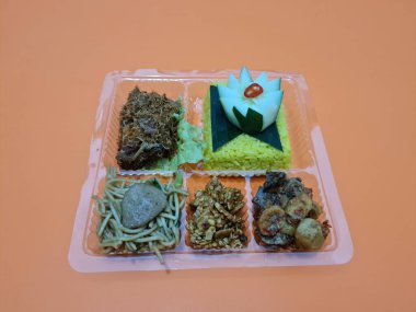 Yellow rice with fried chicken, fried noodles, fried chili and others