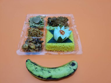 Yellow rice with fried chicken, fried noodles, fried chili and others