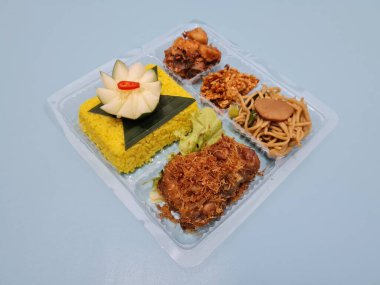 Yellow rice with fried chicken, fried noodles, fried chili and others