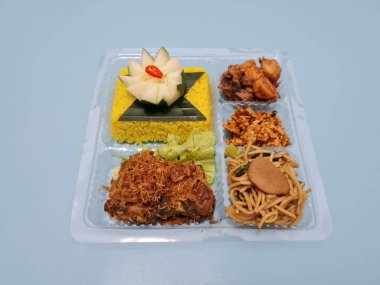Yellow rice with fried chicken, fried noodles, fried chili and others