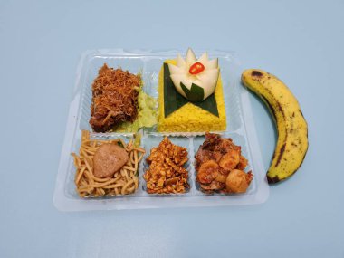 Yellow rice with fried chicken, fried noodles, fried chili and others