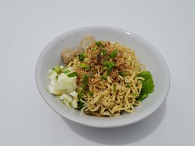 A dish called dumplings, which contains noodles with vegetables plus a pentol in a bowl