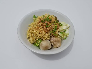 A dish called dumplings, which contains noodles with vegetables plus a pentol in a bowl
