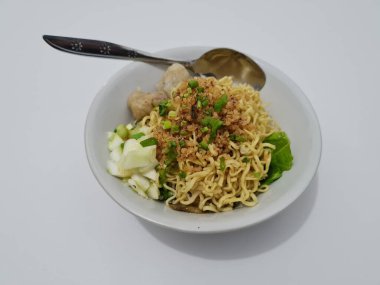 A dish called dumplings, which contains noodles with vegetables plus a pentol in a bowl