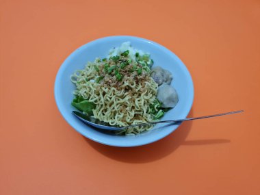 A dish called dumplings, which contains noodles with vegetables plus a pentol in a bowl