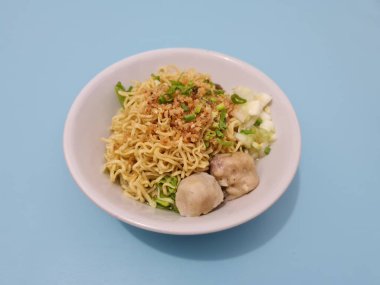 A dish called dumplings, which contains noodles with vegetables plus a pentol in a bowl