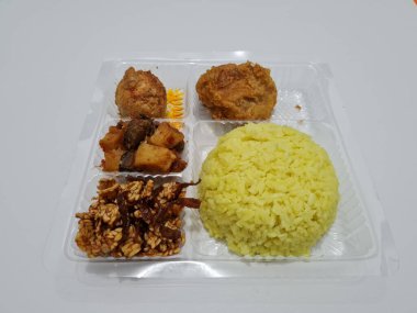 Yellow rice with fried chicken, fried noodles, fried chili and others