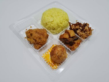 Yellow rice with fried chicken, fried noodles, fried chili and others
