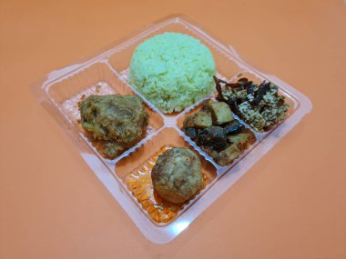 Yellow rice with fried chicken, fried noodles, fried chili and others