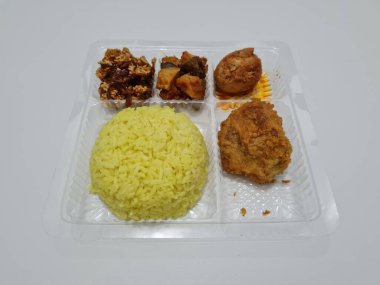 Yellow rice with fried chicken, fried noodles, fried chili and others