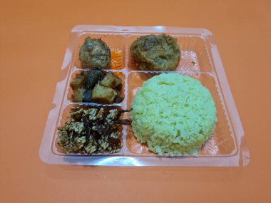 Yellow rice with fried chicken, fried noodles, fried chili and others