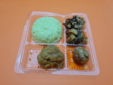 Yellow rice with fried chicken, fried noodles, fried chili and others