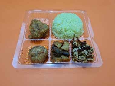 Yellow rice with fried chicken, fried noodles, fried chili and others