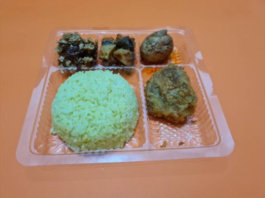 Yellow rice with fried chicken, fried noodles, fried chili and others