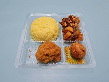 Yellow rice with fried chicken, fried noodles, fried chili and others