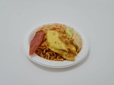 Kızarmış erişteli pilav, kızarmış yumurta, sosis dilimleri ve salatalık dilimleri.