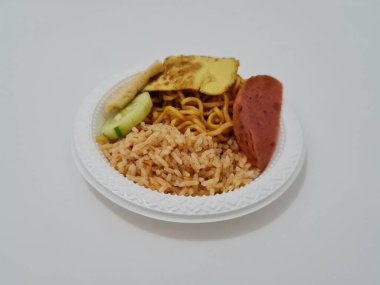 Kızarmış erişteli pilav, kızarmış yumurta, sosis dilimleri ve salatalık dilimleri.