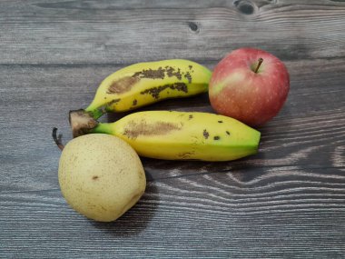 Kırmızı elmalar, sarı muzlar ve armutlardan oluşan taze meyve.