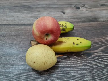 Kırmızı elmalar, sarı muzlar ve armutlardan oluşan taze meyve.