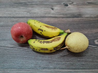 Kırmızı elmalar, sarı muzlar ve armutlardan oluşan taze meyve.