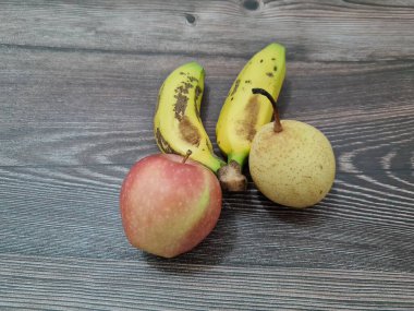 Kırmızı elmalar, sarı muzlar ve armutlardan oluşan taze meyve.