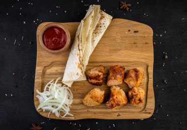 Tahtada kızarmış domuz kebabı, ekmek ve sosla birlikte.