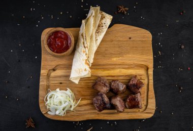 Tahtada kızarmış domuz kebabı, ekmek ve sosla birlikte.