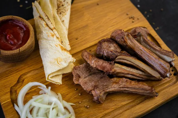 Baharatlı kızarmış domuz pirzolası, ekmek ve ketçaplı.