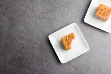 Üst manzara. Mutfaktaki beyaz tabakta bir dilim tatlı patates keki. Fırın ve içecek konsepti.