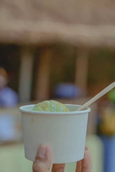 Вкусное Мороженое Авокадо Белой Бумажной Миске Рукой Деревянной Ложкой Копировальным — стоковое фото