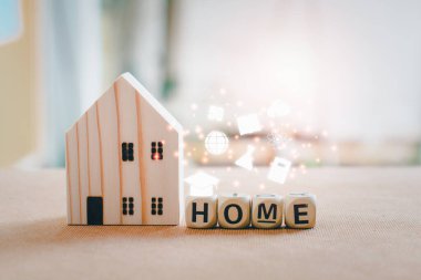 Evde eğitim ve e-öğrenim konsepti. Beyaz eğitim simgeleriyle ahşap ev, kopya alanı olan tahta masa.. 