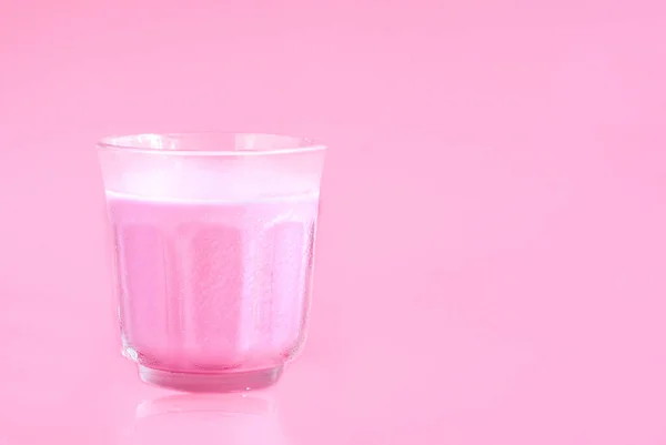 ピンク色の背景に冷たいピンクミルクのガラスは朝食に役立ちました 朝の飲み物のコンセプト — ストック写真