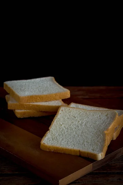 自家做的面包在厨房的木板上滑行 在黑色的背景和复制的空间上 高碳水化合物食物概念 — 图库照片