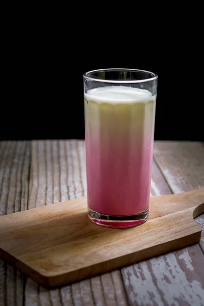 Szklanka Różowego Mleka Drewnianej Tacy Czarnym Tle Koncepcja Zdrowego Napoju — Zdjęcie stockowe