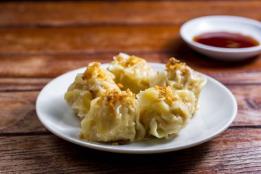 Çin Buharlı Hamur, Shumai beyaz tabakta soya sosuyla servis ediliyor. Lezzetli Dimsum domuz eti..