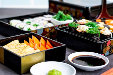 Çeşitli suşi, Tamagoyaki, yengeç budu suşi ve maki sosu, soya sosu ve wasabi ile servis edilir. Lezzetli Japon yemekleri..