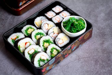 Çeşitli suşi, Tamagoyaki, yengeç budu suşi ve maki sosu, soya sosu ve wasabi ile servis edilir. Lezzetli Japon yemekleri..