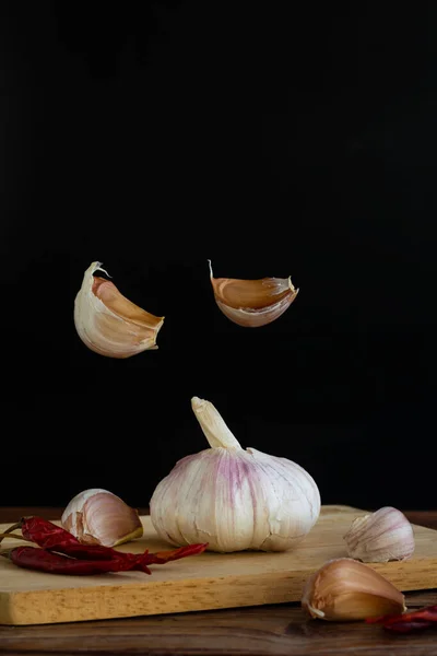 Group Garlic Chopping Board Some Garlic Cloves Floating Air Red — Stock Photo, Image