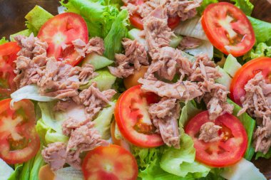 Kırmızı çiğ domatesli ton balığı salatası, taze marul. Düşük vitaminli ve düşük yağlı. Sağlıklı gıda konsepti.