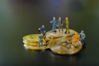 Minyatür insanlar takım çalışması, küçük model insan figürü ayakta duruyor ve metin için kopyalama alanı olan altın Bitcoin 'leri eşeliyor. Kripto para birimi veya dijital para kavramı.