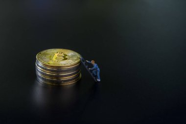 Minyatür insanlar takım çalışması, küçük model insan figürü. Metnin için kopyalama alanı olan altın Bitcoins yığınına tırman. Kripto para birimi veya dijital para kavramı.