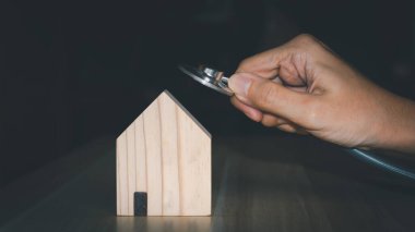 Ev onarımı ve müfettiş konsepti. Steteskop, ahşap evi kontrol ediyor.. 