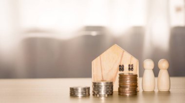 İş ve emlak kavramı. Ahşap bir ev ve para yığını gibi duruyor. Gelecek için tasarruf ve yatırım, krediler, bankacılık, hisse senedi ve fon. 
