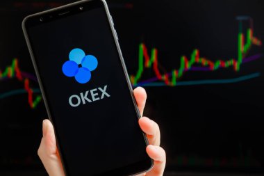 Ukrayna, Odessa - Ekim, 9, 2021: OKEx mobil uygulaması arka planda ticari şamdan şeması ile akıllı telefon ekranında çalışıyor. OKEx kripto döviz ve ticaret platformudur.