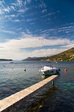 Dar ahşap köprüsü ve gün batımında küçük teknesi olan muhteşem bir Hırvat deniz manzarası. Dubrovnik, Hırvatistan. Seyahat kavramı