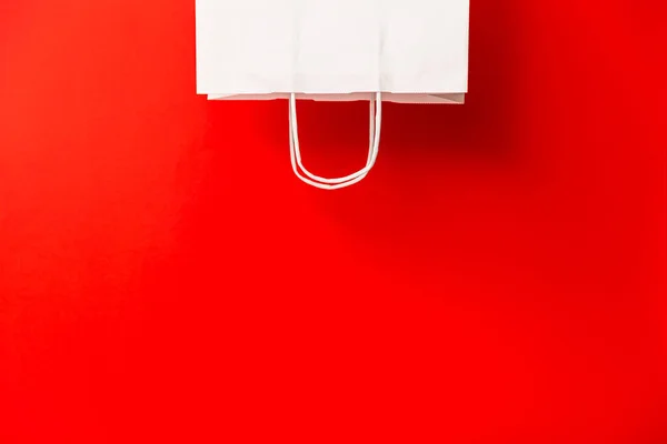 Blank white paper bag isolated on red background. Black friday, sale, discount, recycling, shopping and ecology concept